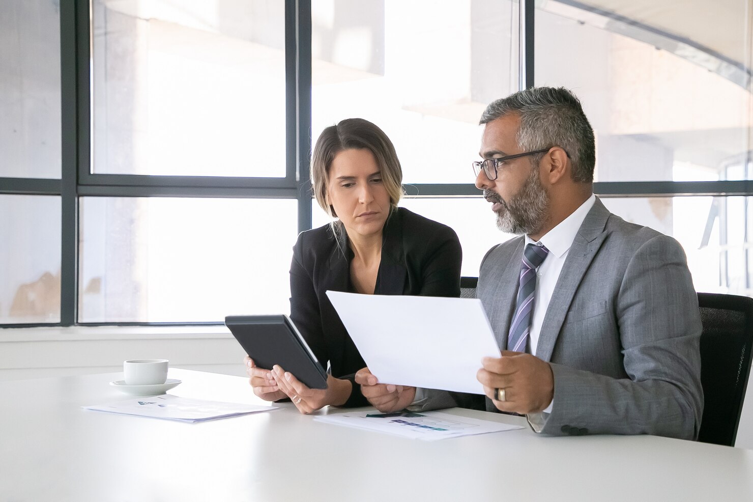 lideres empresa analizando informes dos companeros trabajo sentados juntos mirando documento sosteniendo tableta hablando tiro medio concepto comunicacion 74855 11619